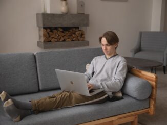 Person sidder i sofa på computeren